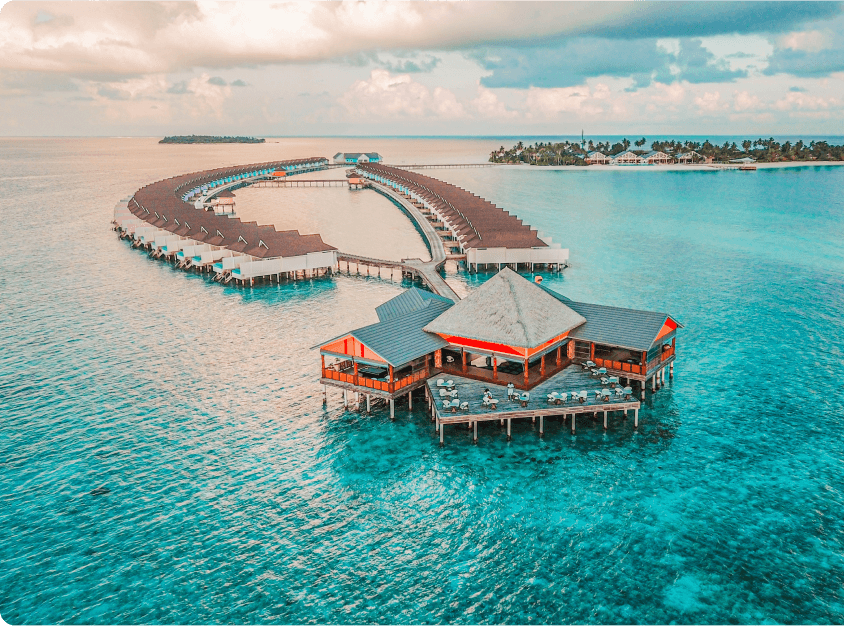 https://www.travel-ups.com/wp-content/uploads/2023/02/aerial-view-beautiful-hotel-water-ocean-sunset.png